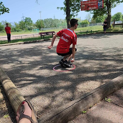 Boule-Spieler zielt bei einem niedrigen Wurd