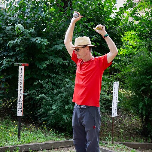 Boule-Spieler strecktsich vor dem Wurf